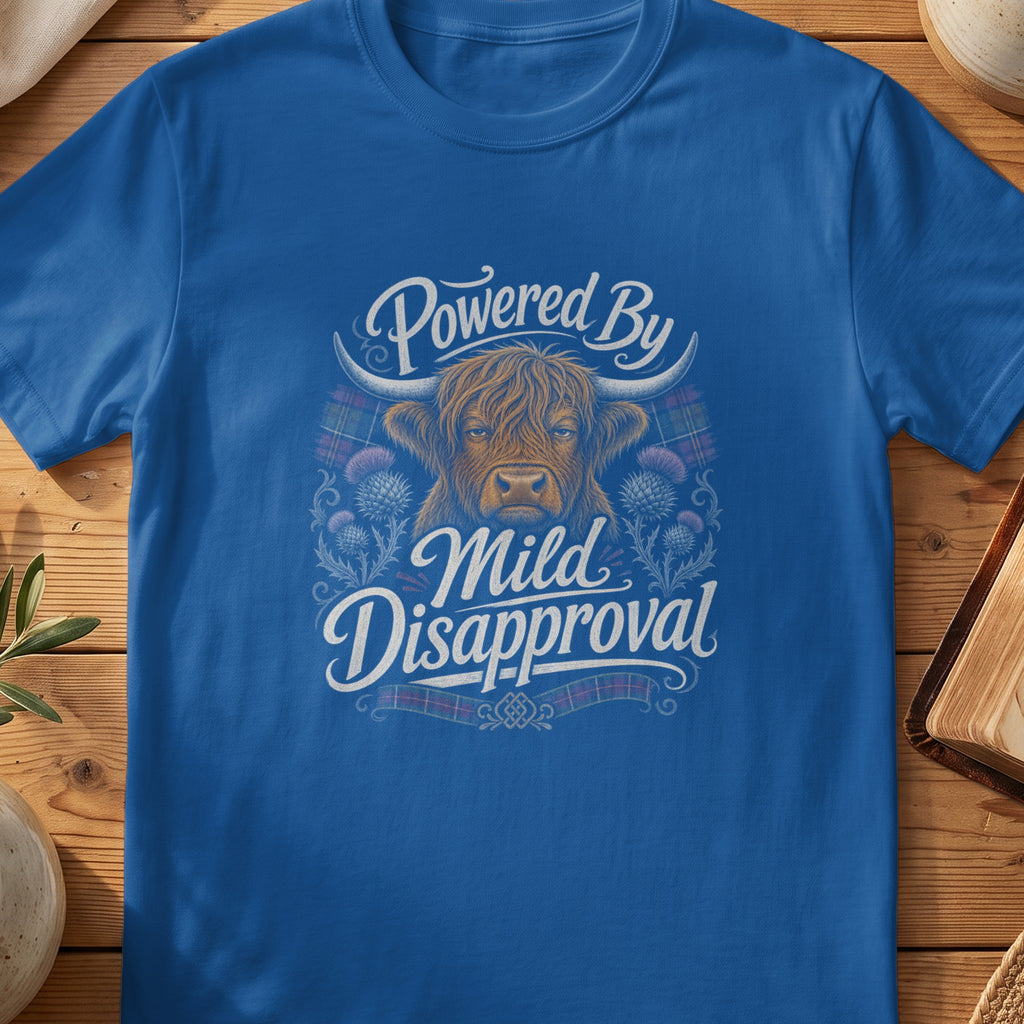 Highland cow illustration with text "Powered By Mild Disapproval" on a blue t-shirt.