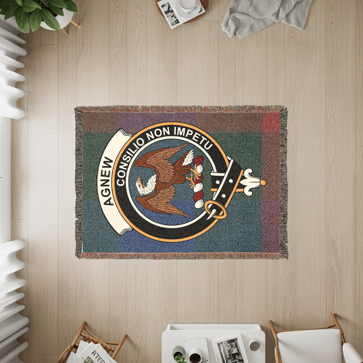 Agnew woven blanket displayed on a wall, featuring the crest badge and tartan background