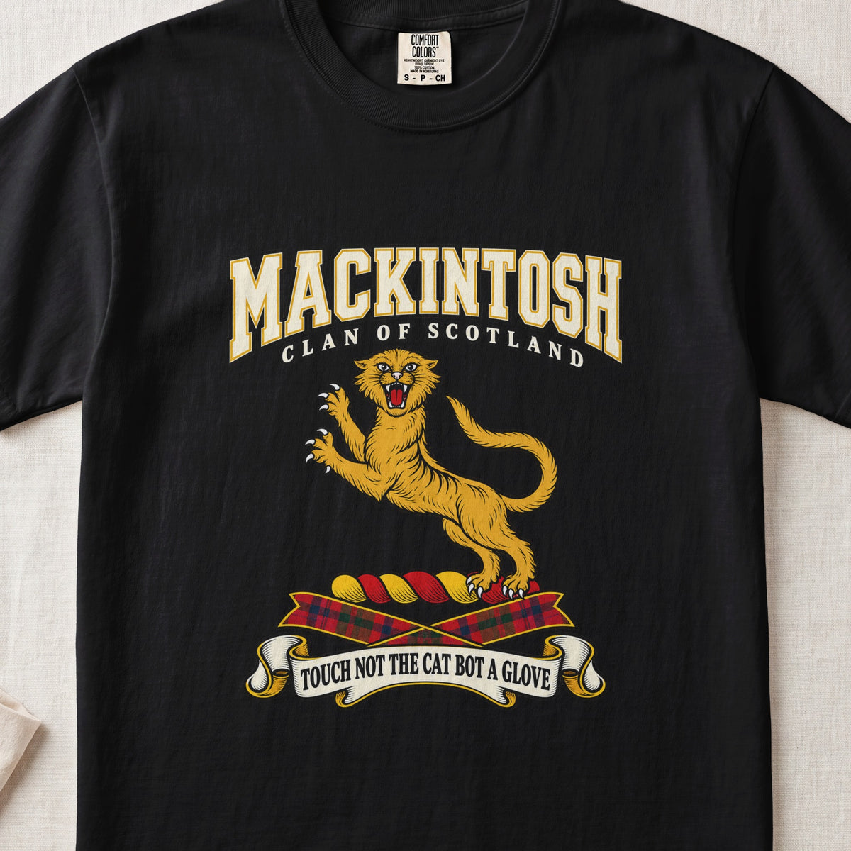 MacKintosh graphic T-shirt in Black, front flat lay showing varsity lettering and gold leaping wildcat with raised claws and open mouth.