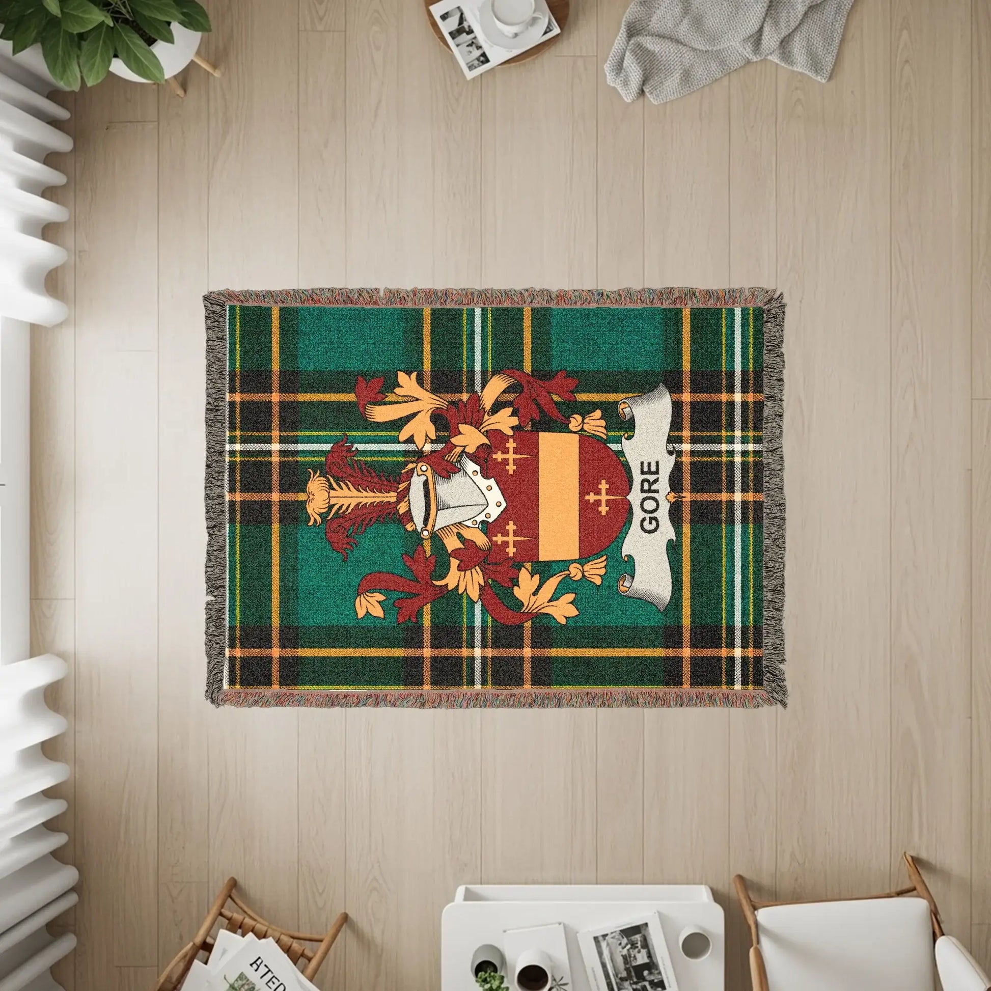 Gore clan crest on a green plaid throw blanket.