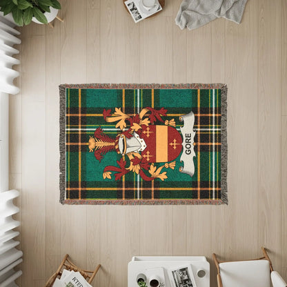 Gore clan crest on a green plaid throw blanket.