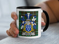 White mug with black rim featuring a family crest with the name "BAILLIE".