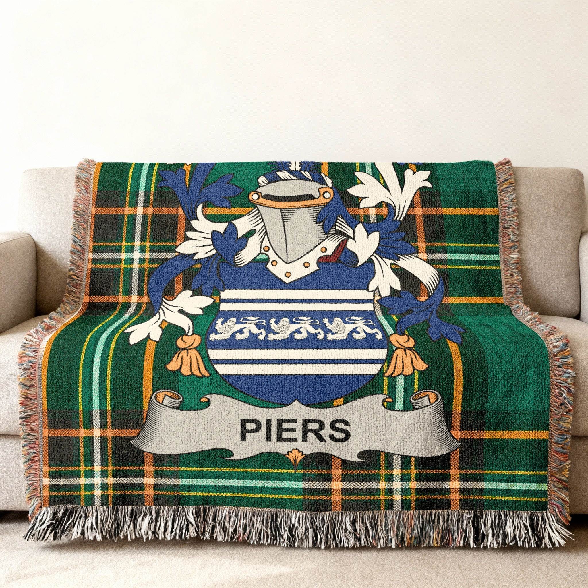 Piers family crest on a green tartan throw blanket with fringe.