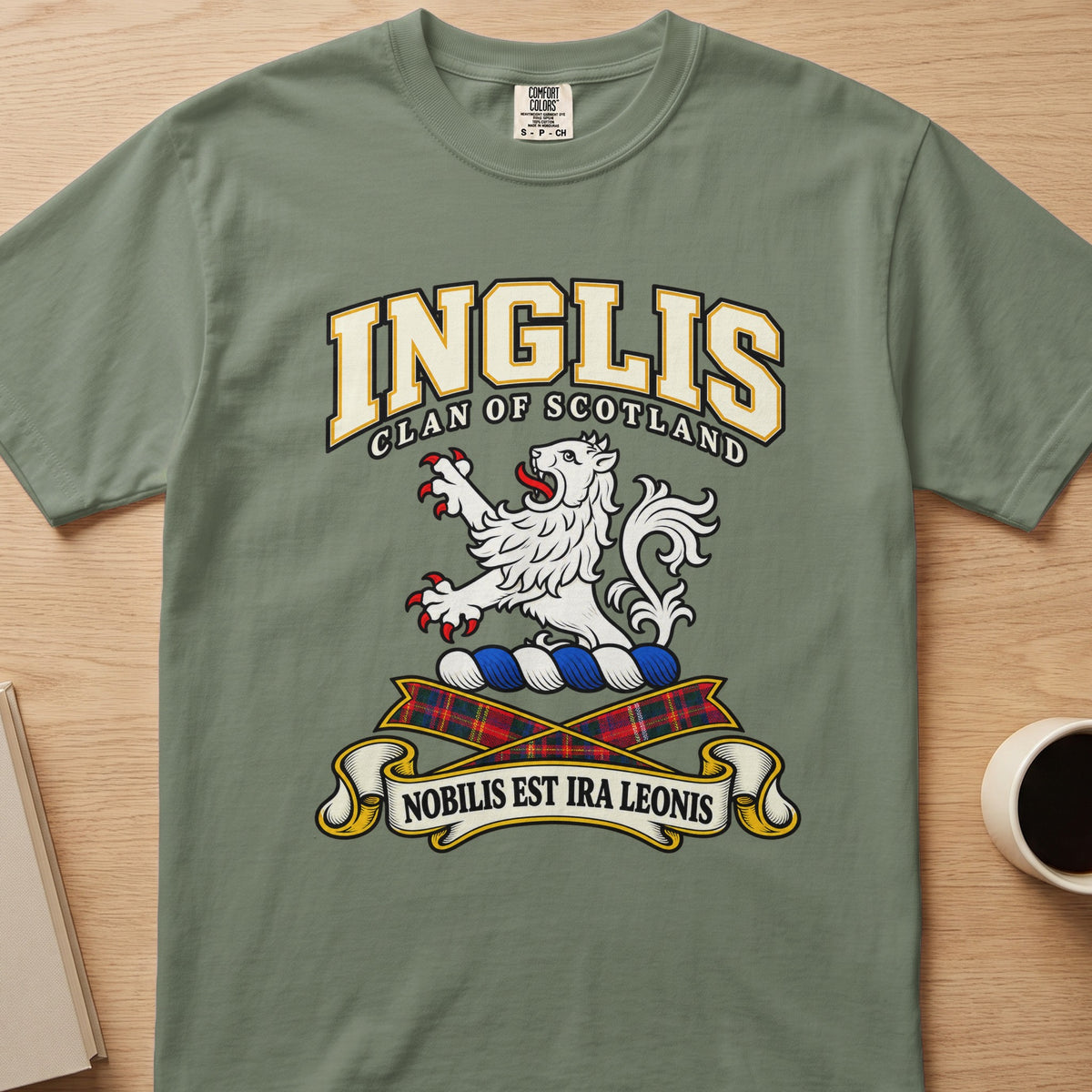 Inglis clan crest with white lion on a sage green Comfort Colors T-shirt, front view