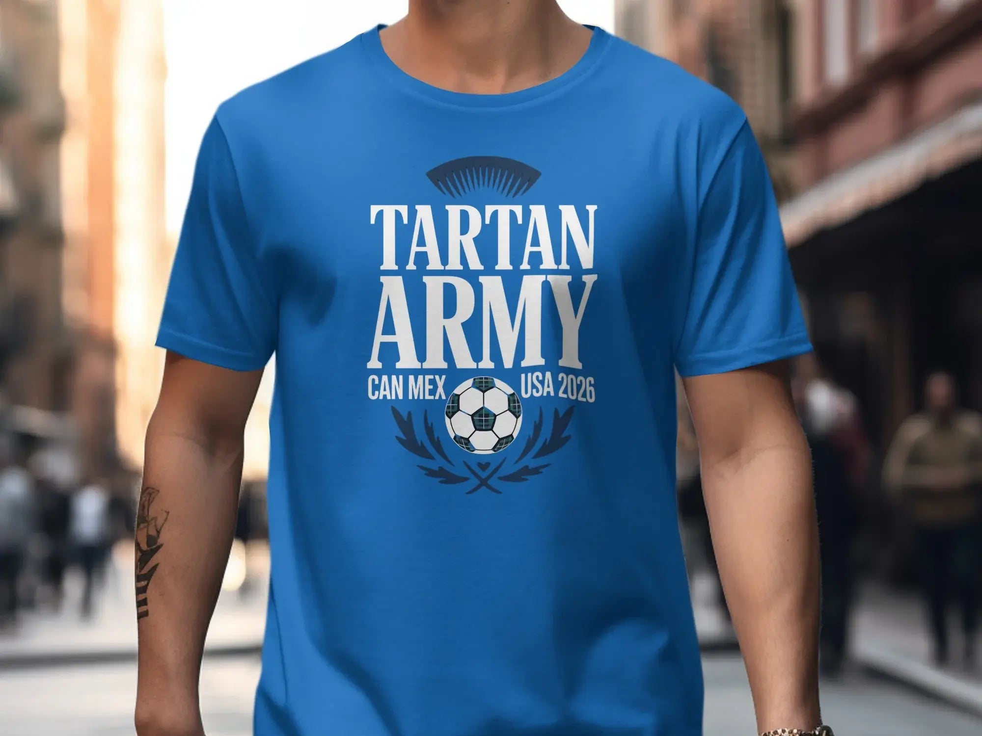 Blue t-shirt with "Tartan Army Can Mex USA 2026" text and soccer graphic.