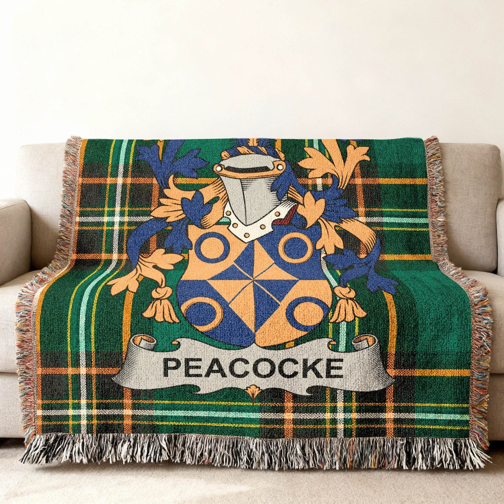 Woven throw blanket with a green plaid pattern and a family crest with the name "PEACOCKe".