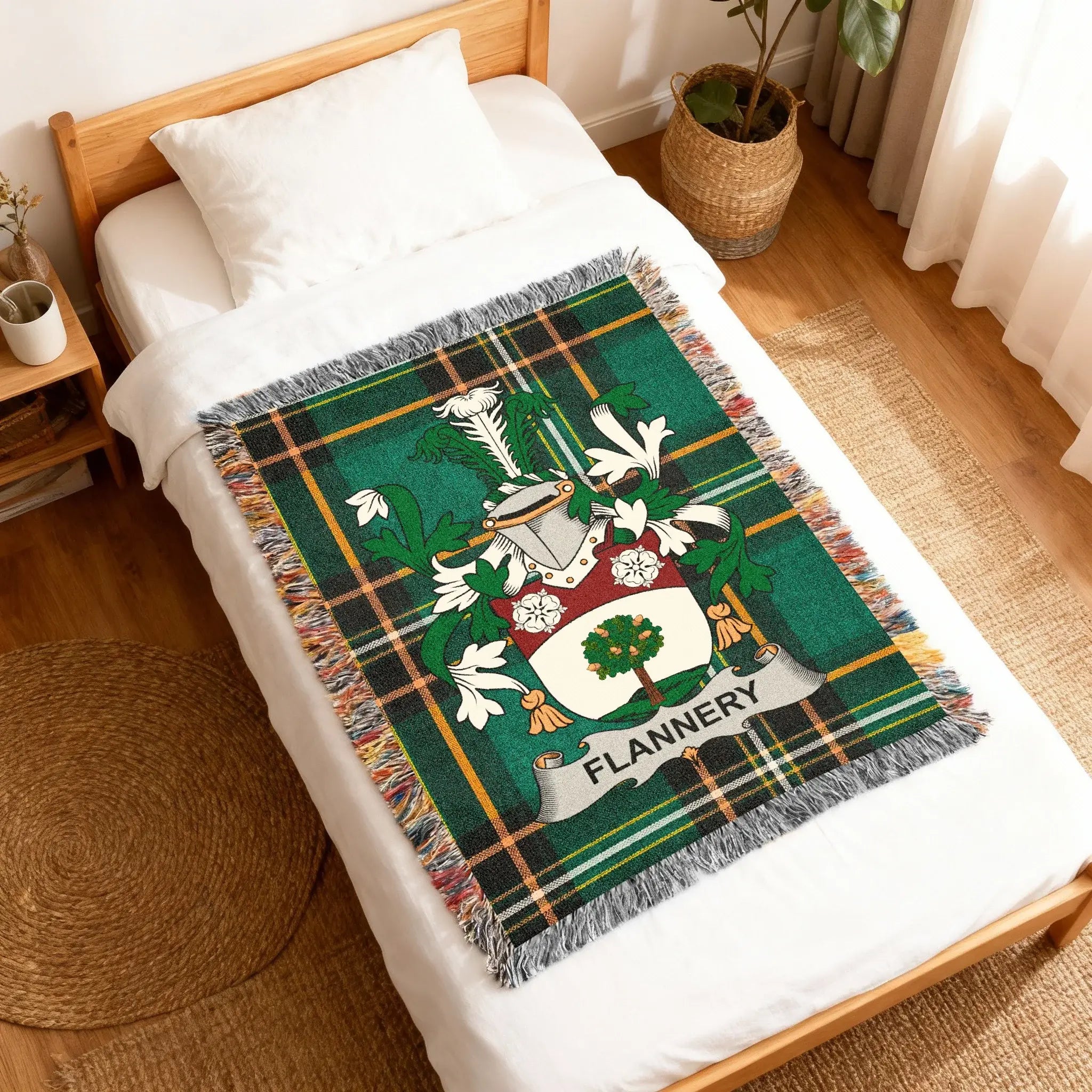 Green tartan blanket with Flannery family crest on a bed.