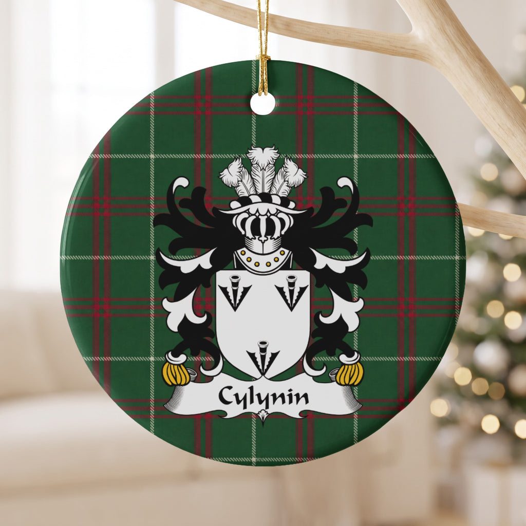 Cylynin ornament hanging from a pale wooden branch; three black arrowhead motifs on a white shield on Welsh national tartan.