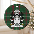 Cylynin ornament hanging from a pale wooden branch; three black arrowhead motifs on a white shield on Welsh national tartan.