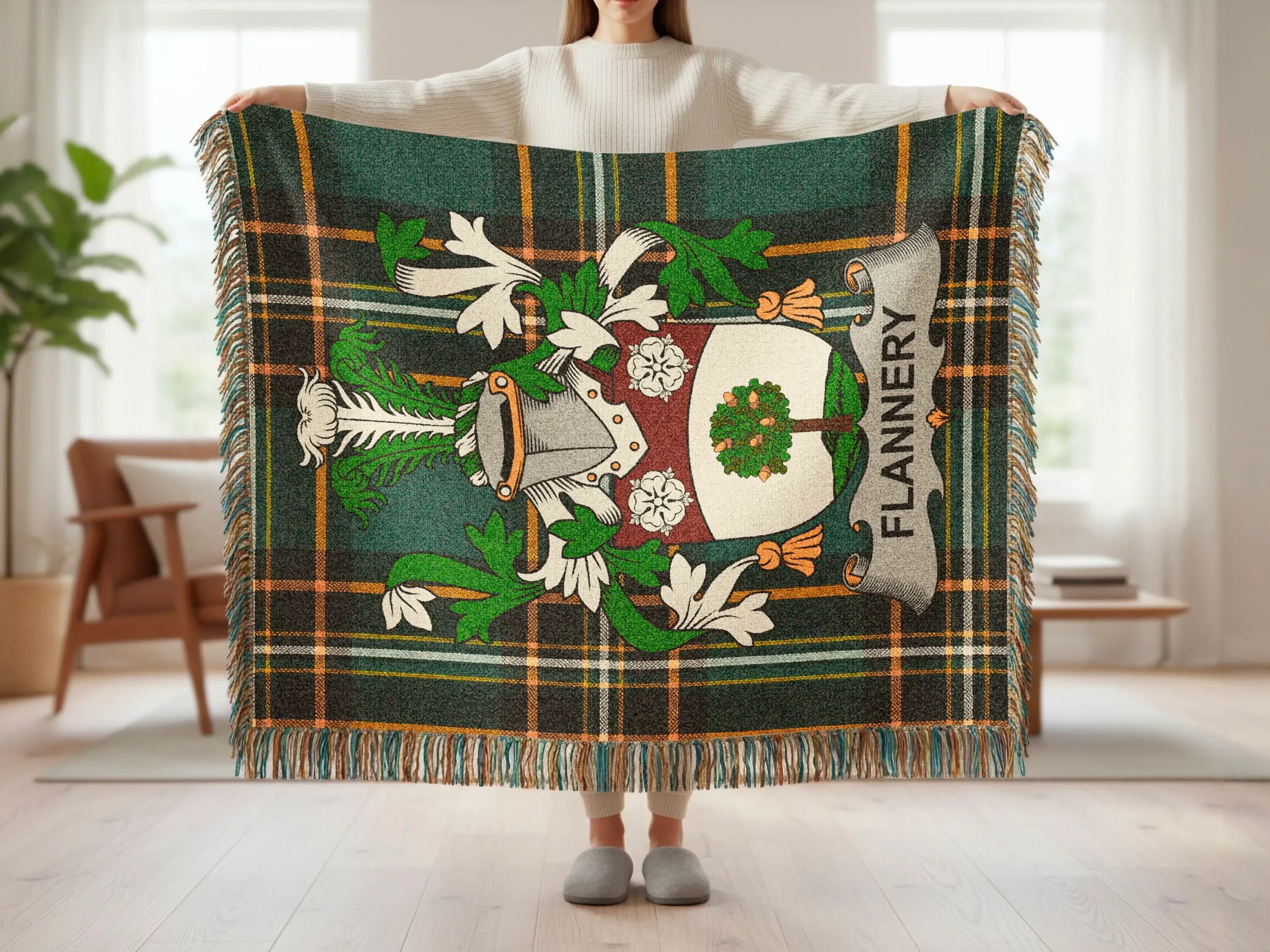 Green tartan blanket with Flannery coat of arms and fringed edges.