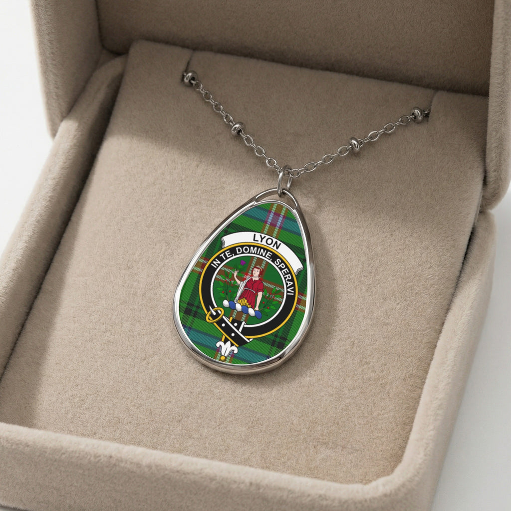 Oval pendant necklace with Lyon tartan, motto, and crest on display.