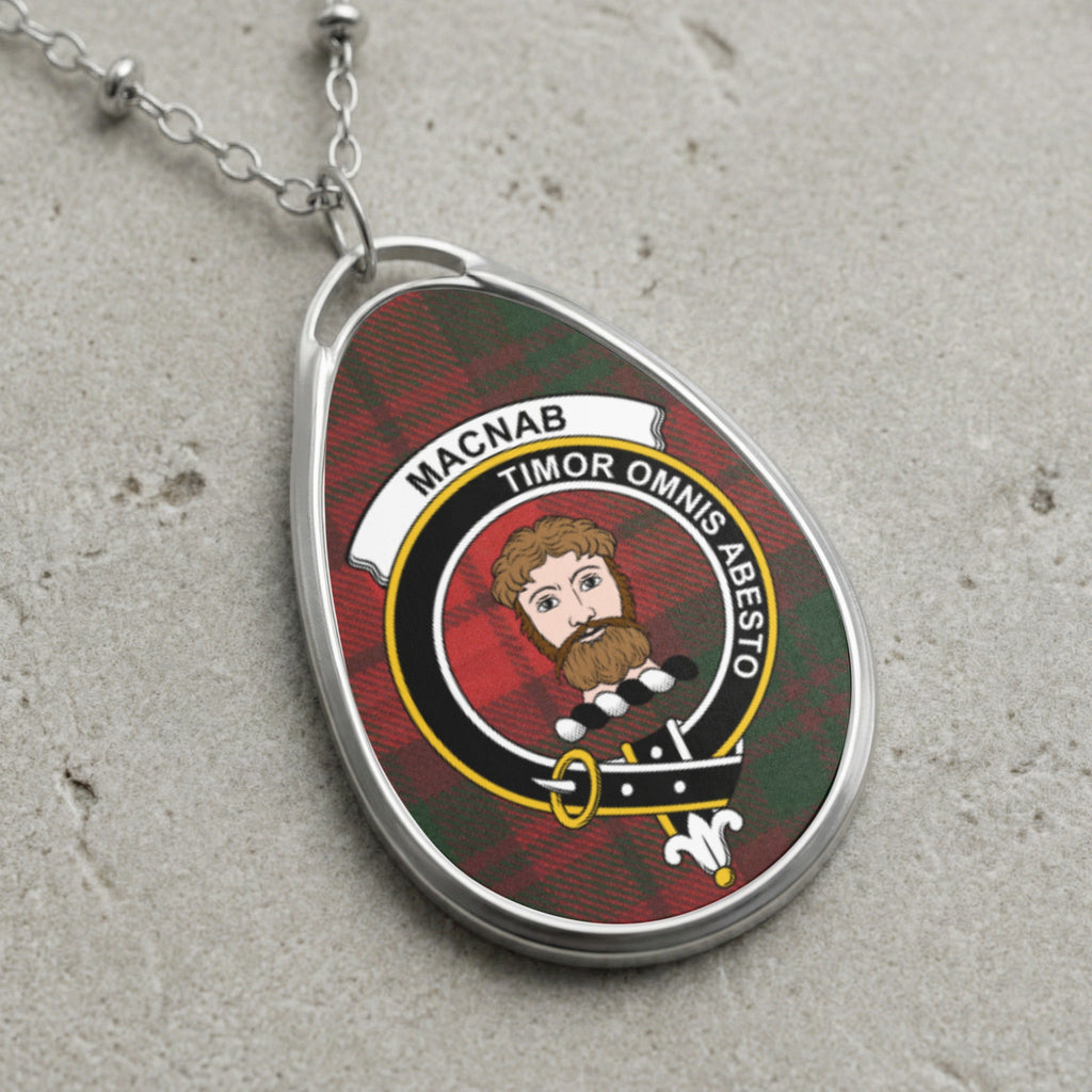 Oval clan crest pendant with tartan background and motto "Timor Omnis Abesto".