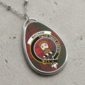 Oval clan crest pendant with tartan background and motto "Timor Omnis Abesto".