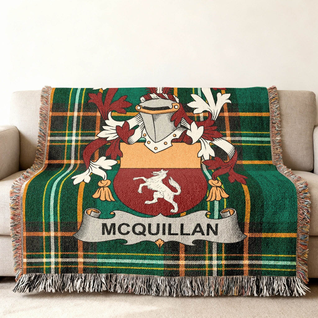 Green tartan blanket with McQuillan coat of arms on a sofa.