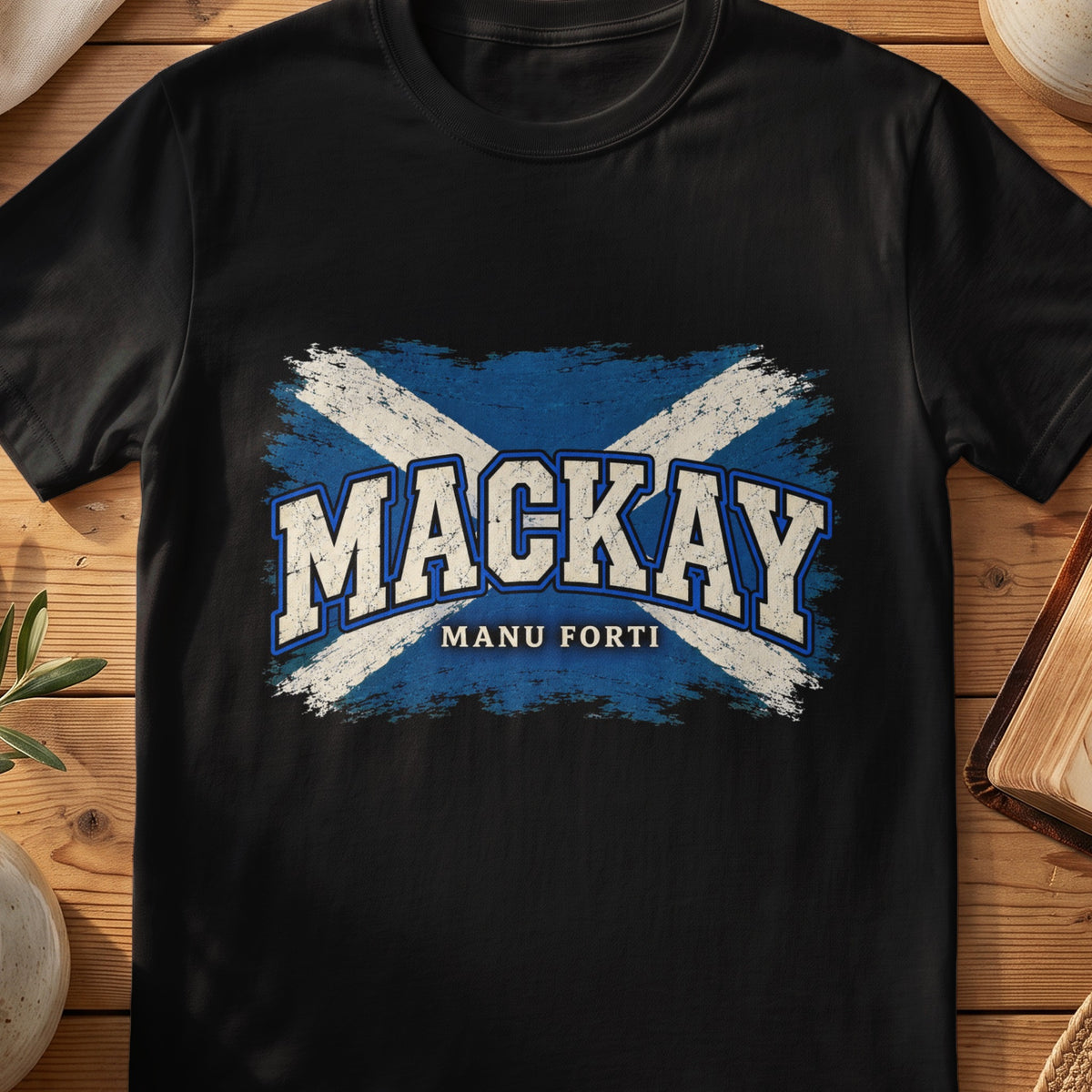 MacKay Scottish Saltire T-shirt in Black, with distressed blue and cream flag and “Manu Forti” lettering.