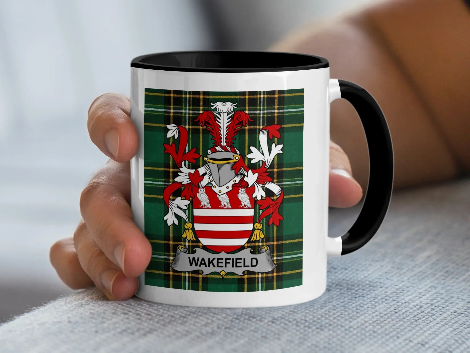 White mug with black rim featuring the Wakefield family crest on a tartan background.
