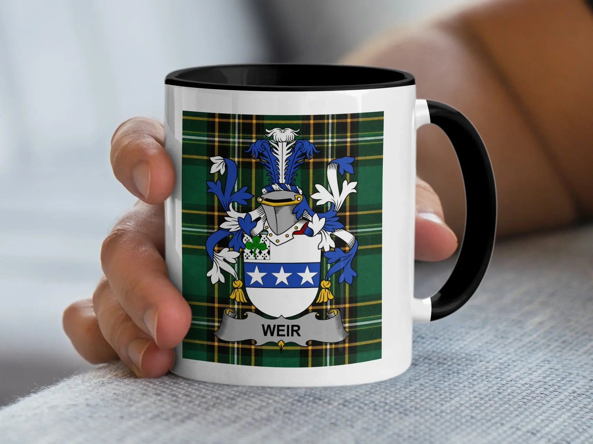White mug with black rim, displaying the Weir family crest on a tartan background.