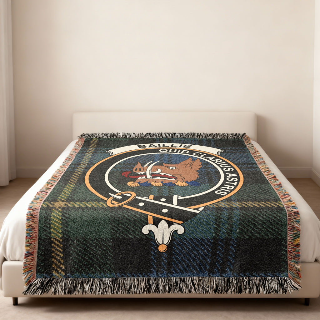 Baillie Scottish woven blanket spread across a bed, showing the full crest design and tartan background