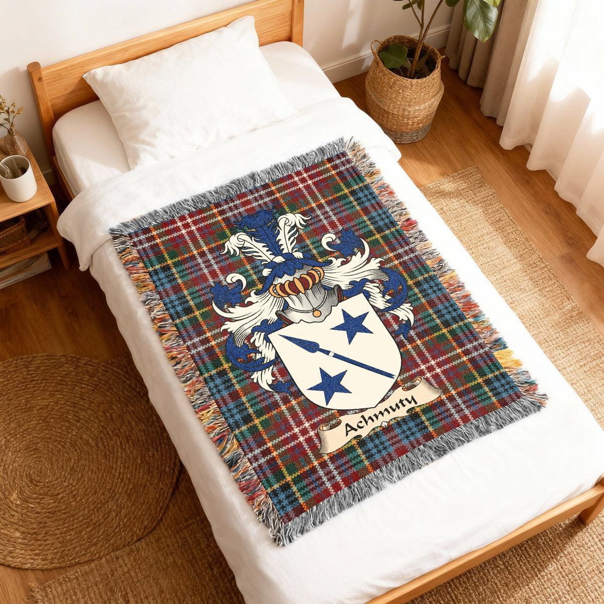 Achmuty Scottish family shield woven blanket with Caledonia tartan background, displayed on a bed