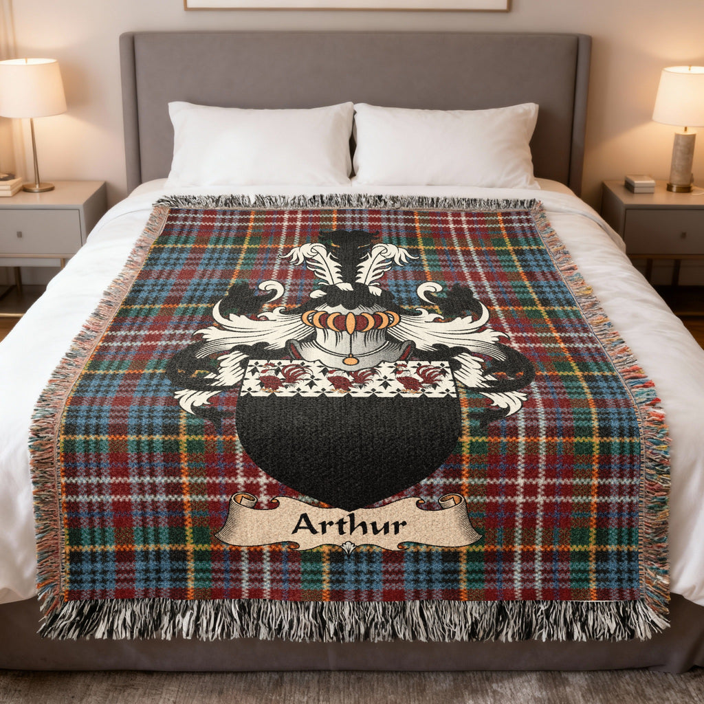 Arthur Scottish family crest woven blanket on a Caledonia tartan background, displayed on a bed