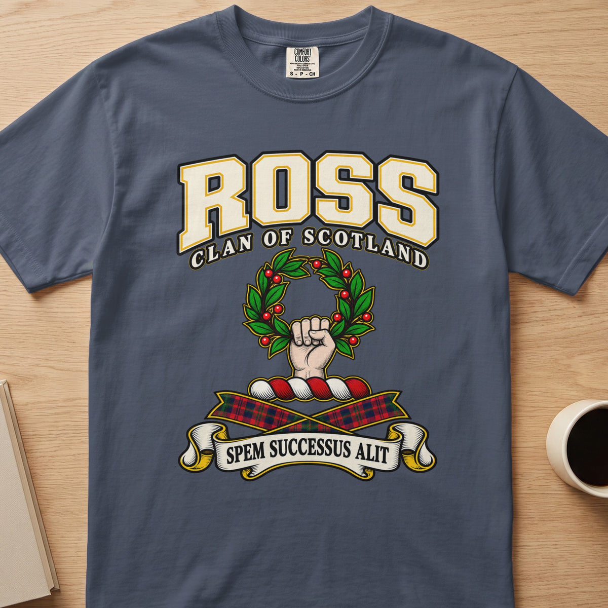 Ross raised hand holding a green wreath graphic on a slate blue Comfort Colors T-shirt, front view