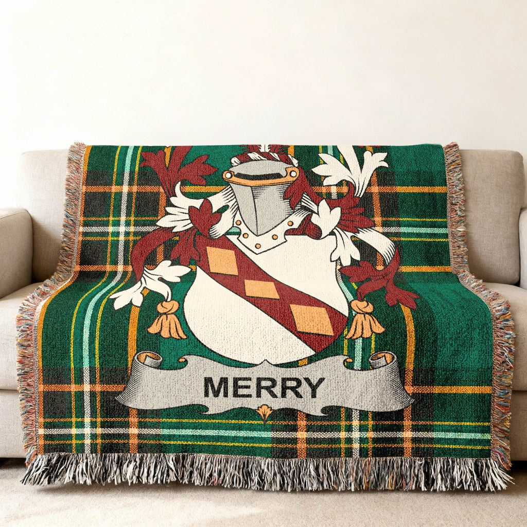 Green plaid throw blanket with Merry family crest draped over a sofa.