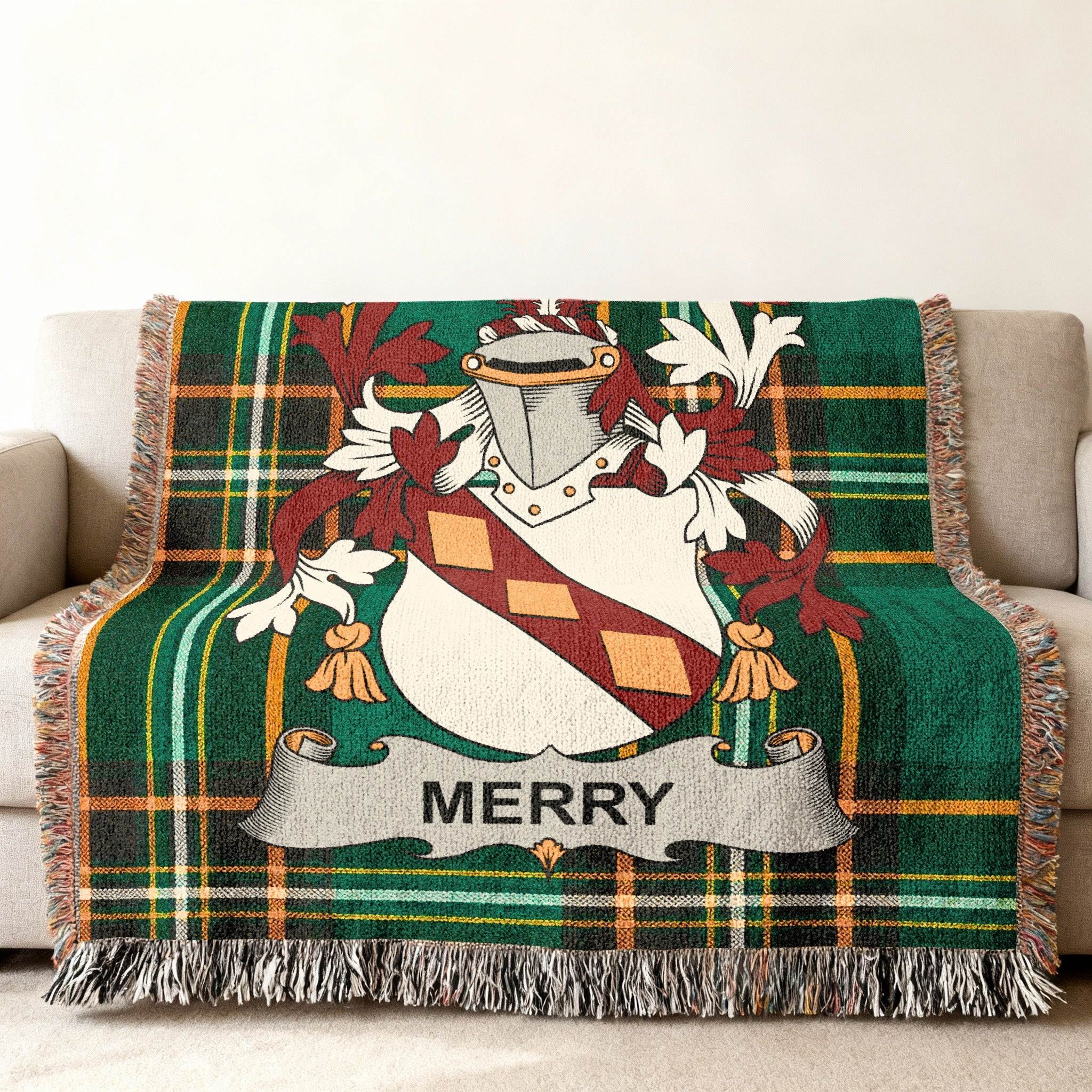 Green plaid throw blanket with Merry family crest draped over a sofa.