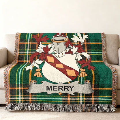 Green plaid throw blanket with Merry family crest draped over a sofa.