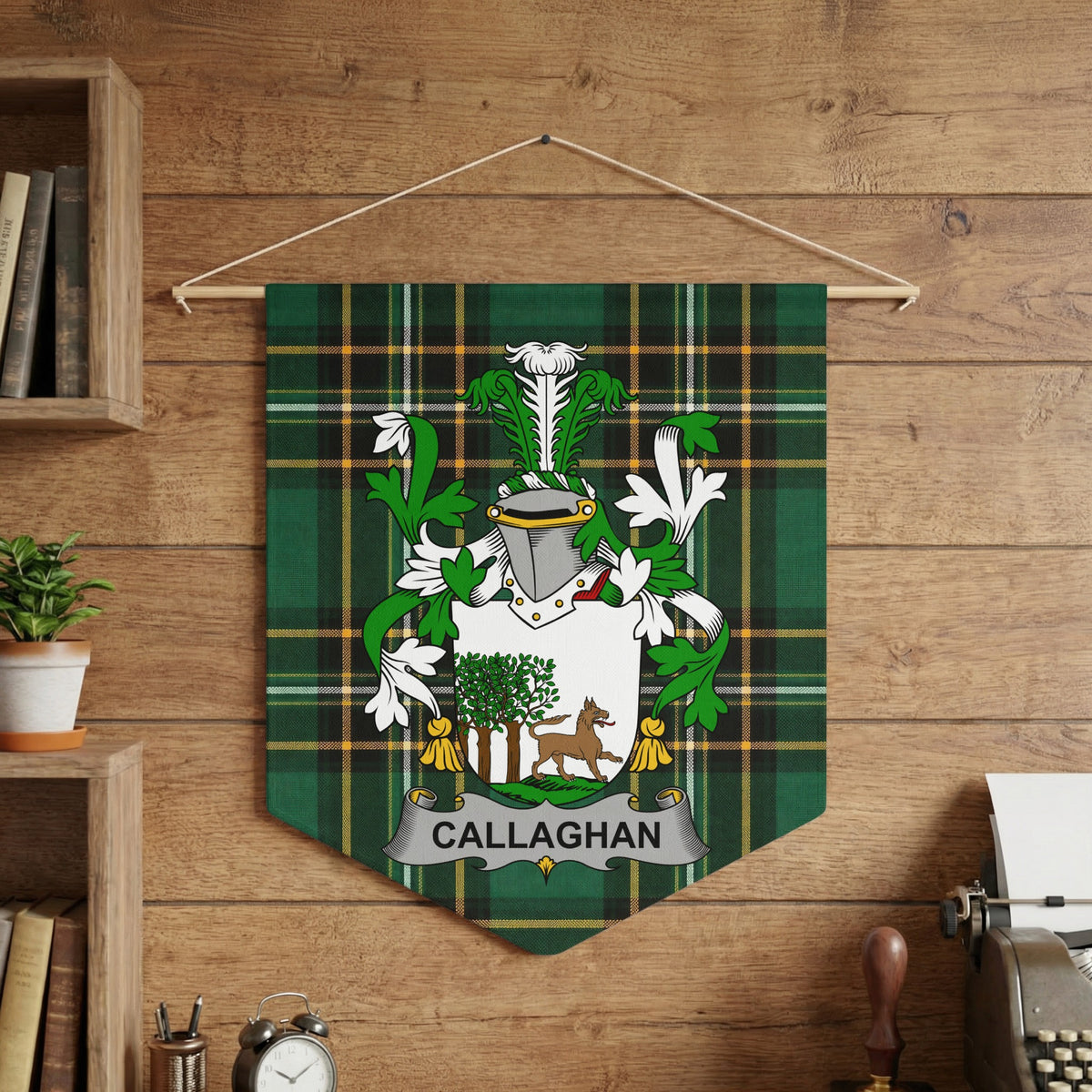 Callaghan crest on green tartan pennant hanging on wood-paneled wall.