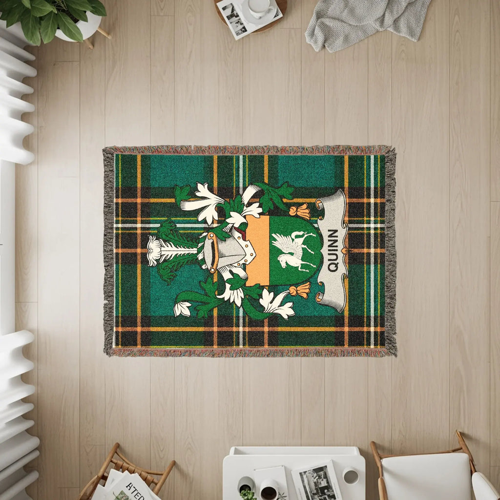 Green plaid woven blanket featuring the Quinn family crest.
