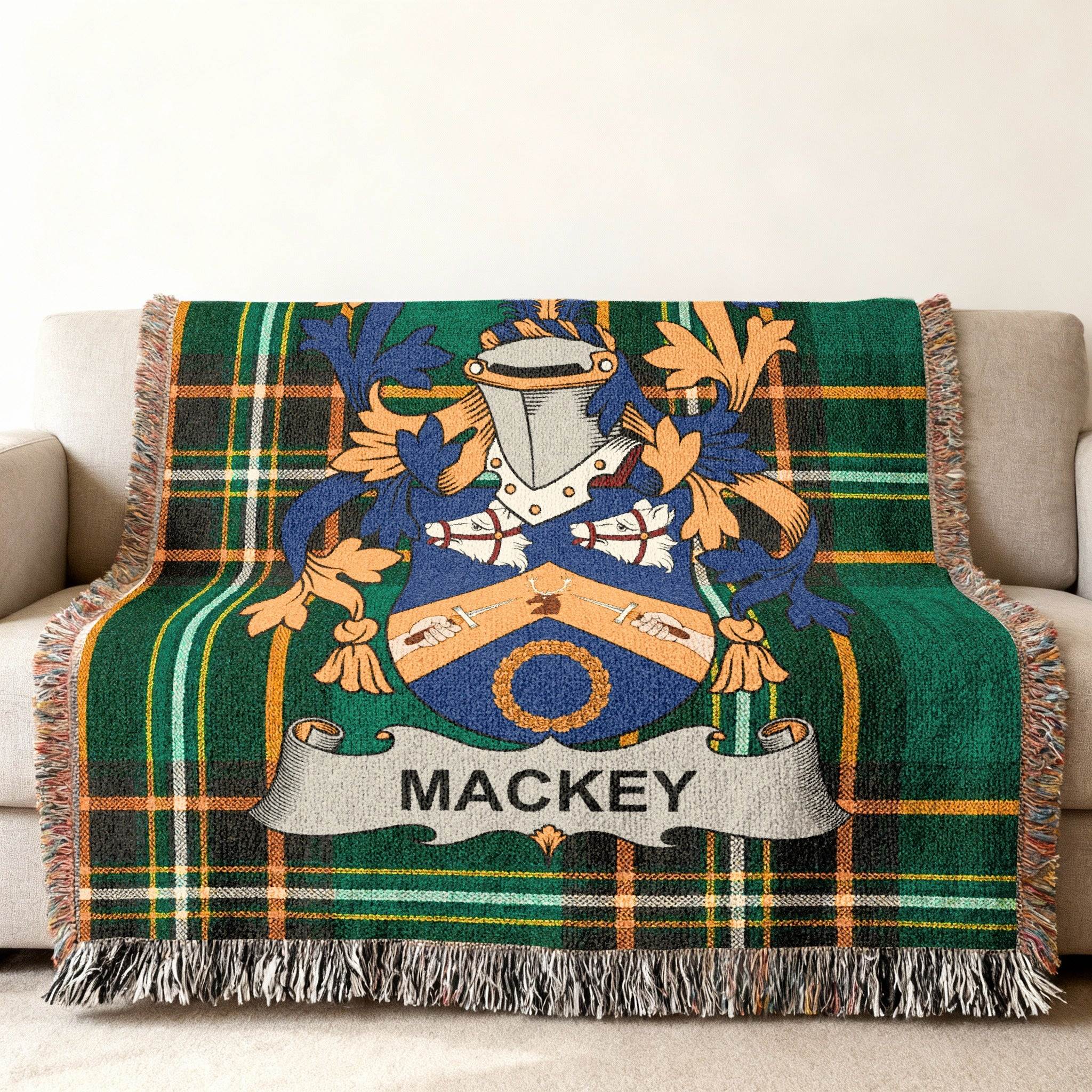 Woven blanket with green plaid and a Mackey family crest.