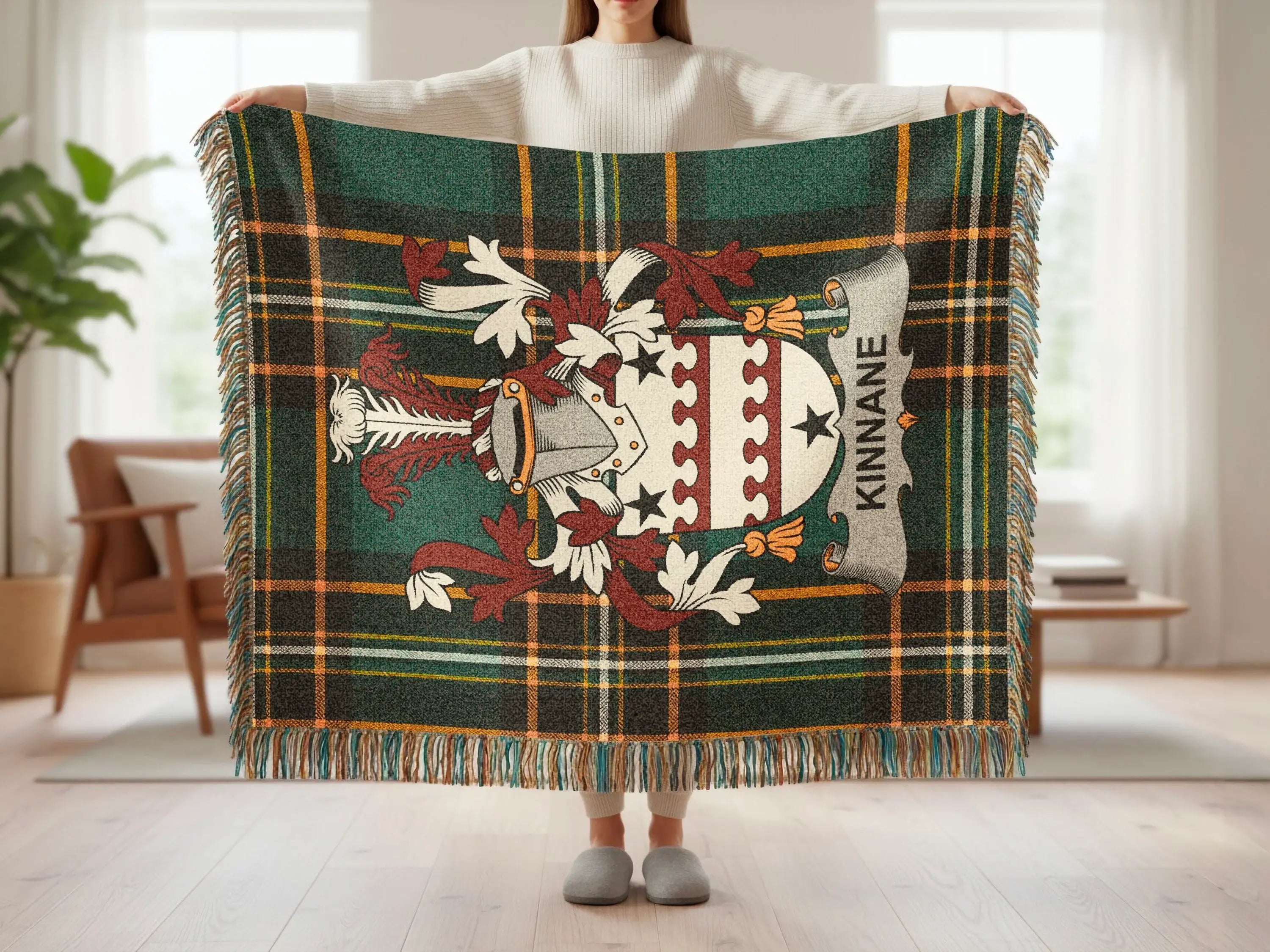 Tartan plaid throw blanket with a shield crest and "KINNASE" text.