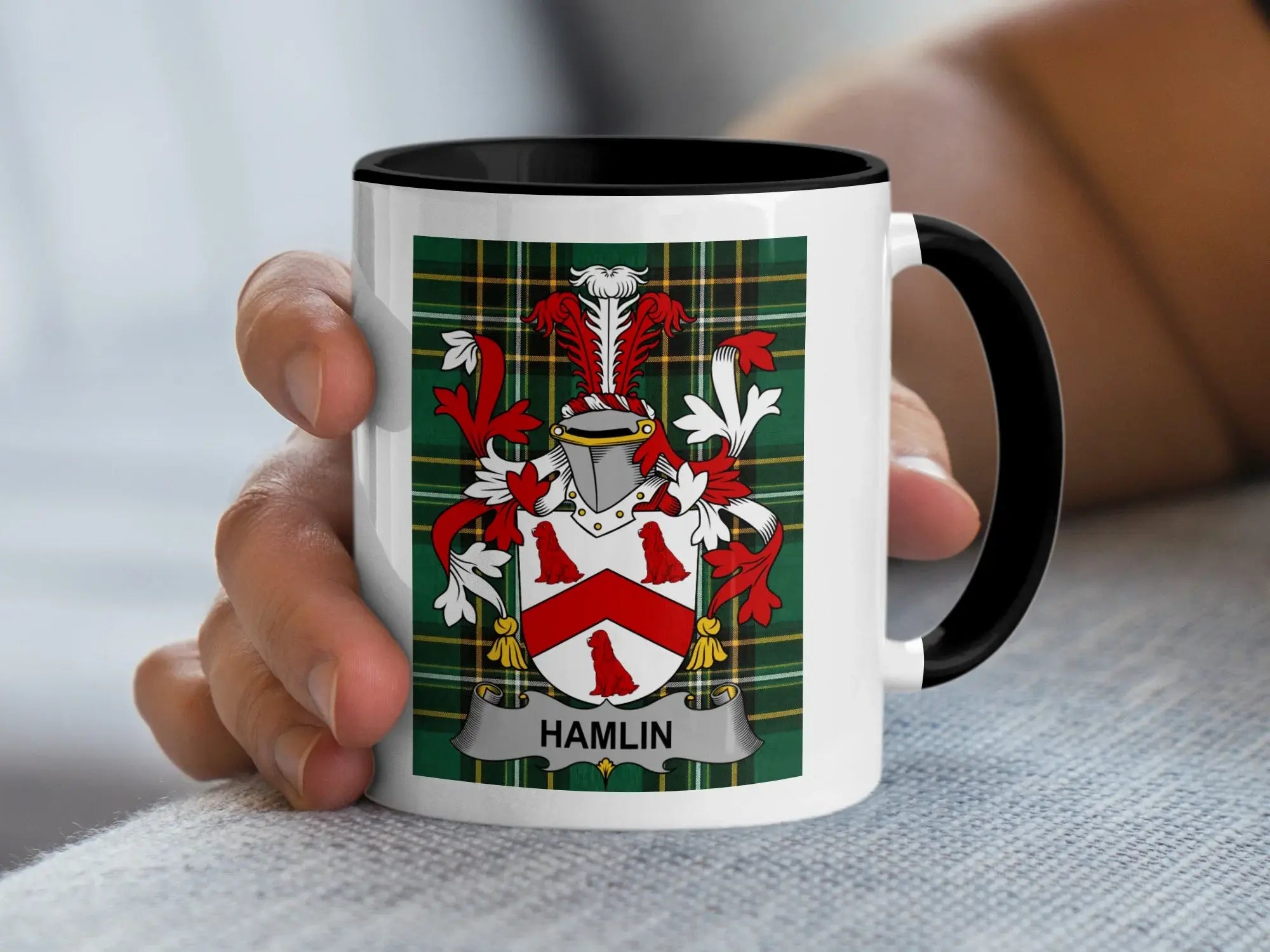 White mug with black trim displaying the Hamlin family crest on a tartan background.
