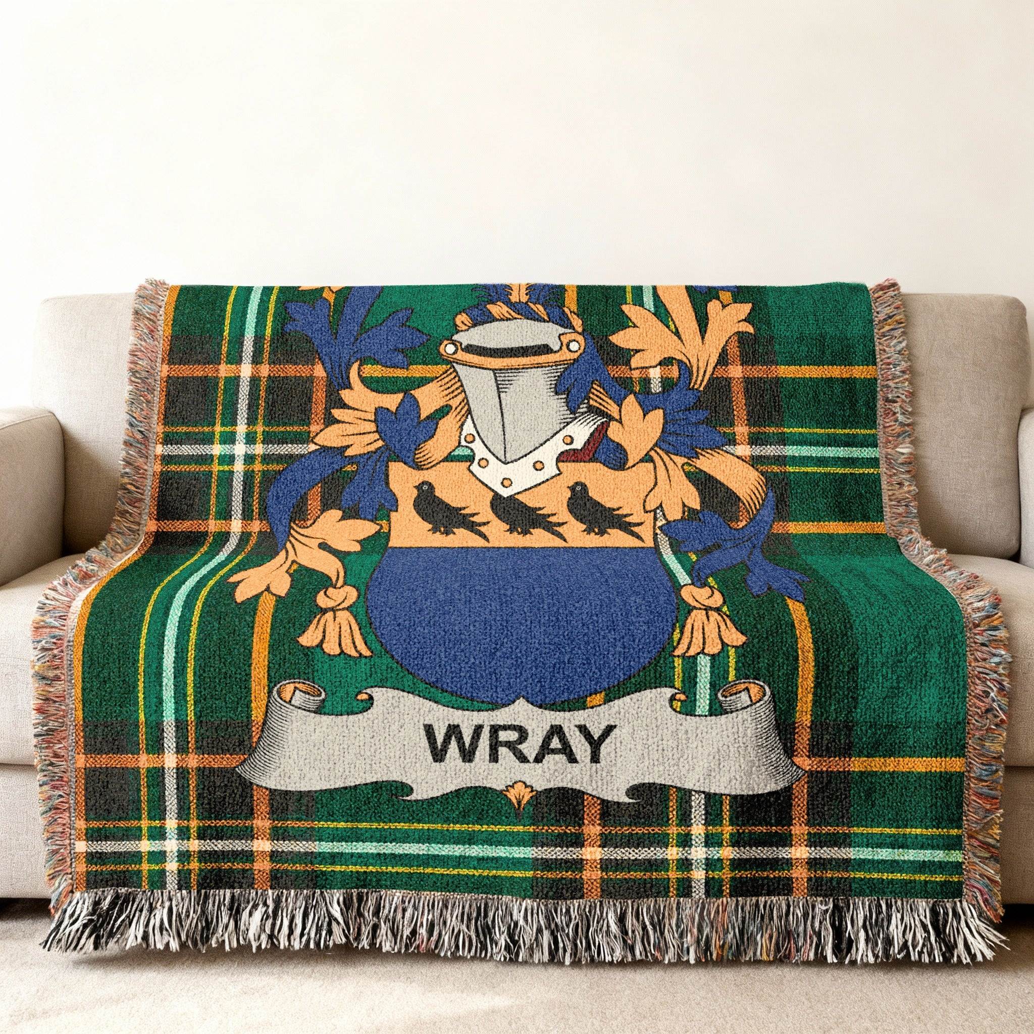 Wray family crest on a green plaid throw blanket with fringed edges.