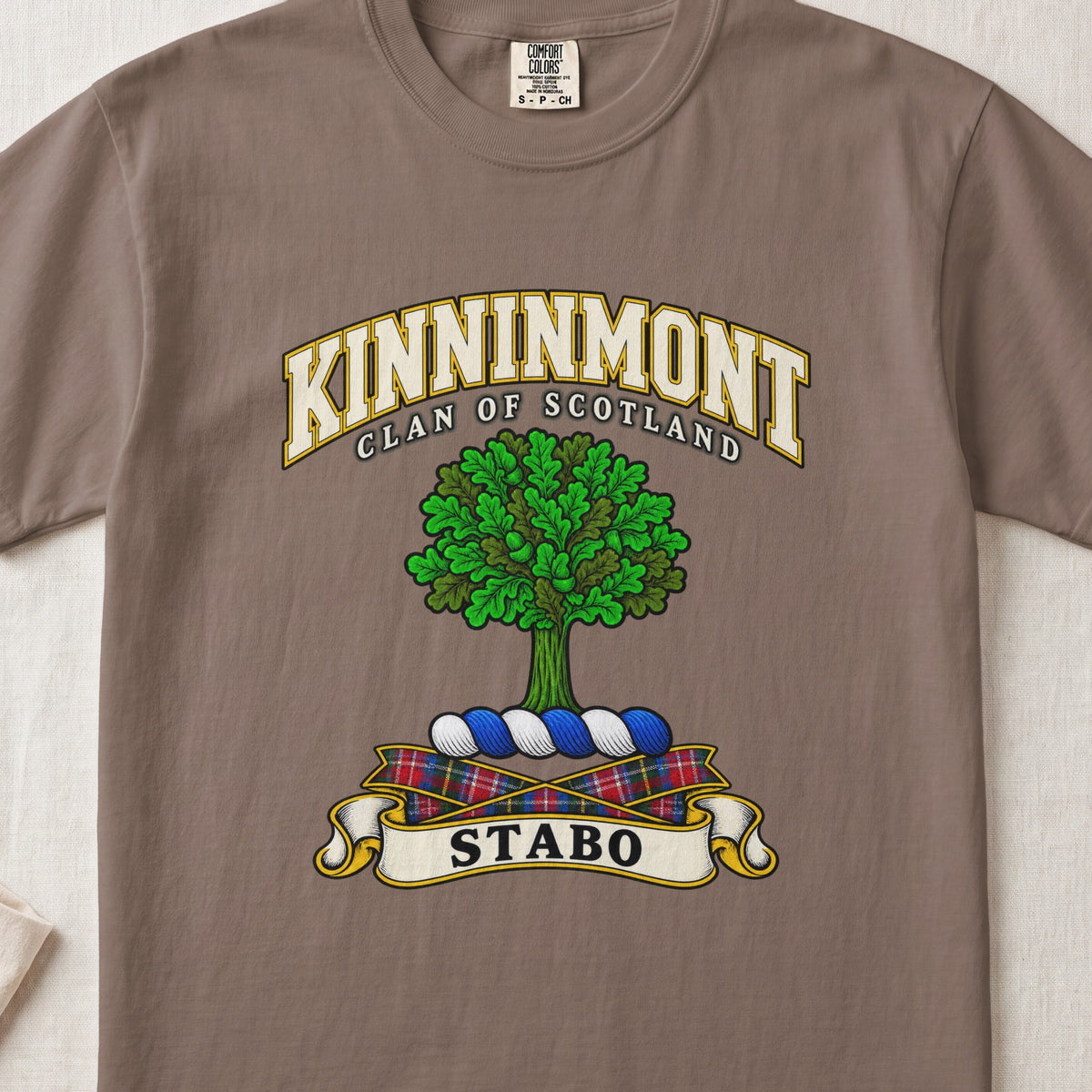 Kinninmont Scottish clan T-shirt in Espresso, front view with a green tree and motto banner.