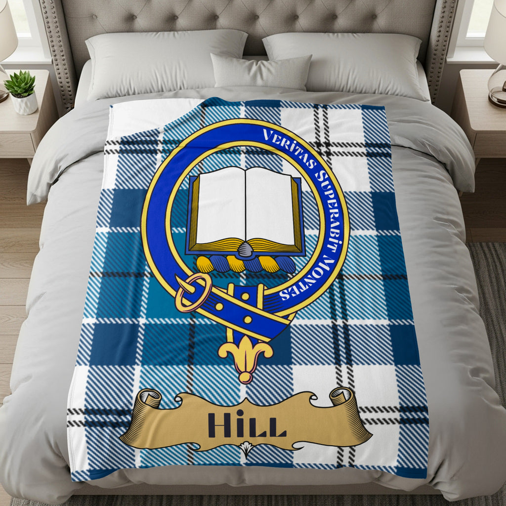 Hill clan crest with Veritas Superabit Montes motto on blue tartan throw