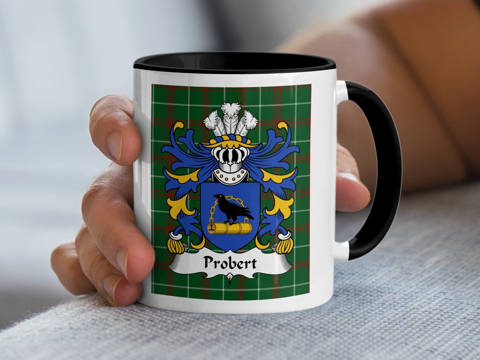 Mug with Probert family crest on green tartan background, held by a hand.