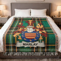Tartan blanket featuring the Marlay family crest, draped on a bed.