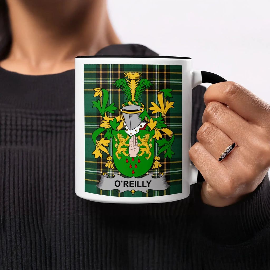 O'Reilly crest on a white mug with black rim, held by a person.