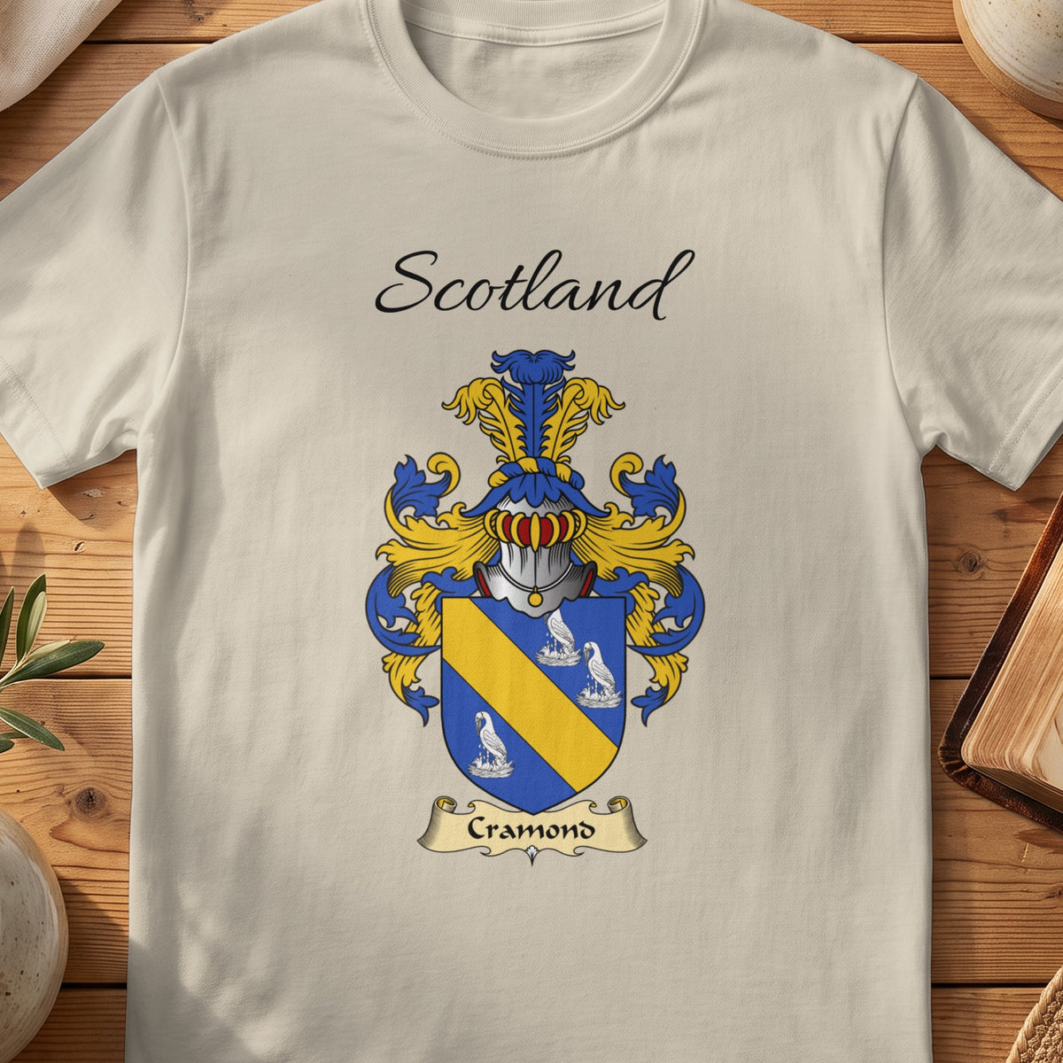 Sand Cramond Scottish family shield T-shirt featuring a gold diagonal band between pale motifs on blue