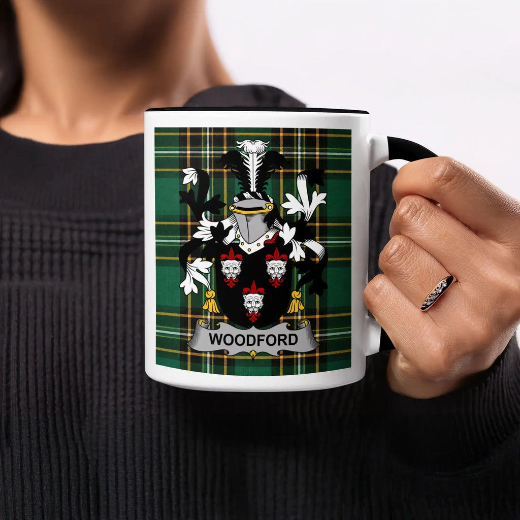Woodford family crest on a green plaid mug, held by a person.