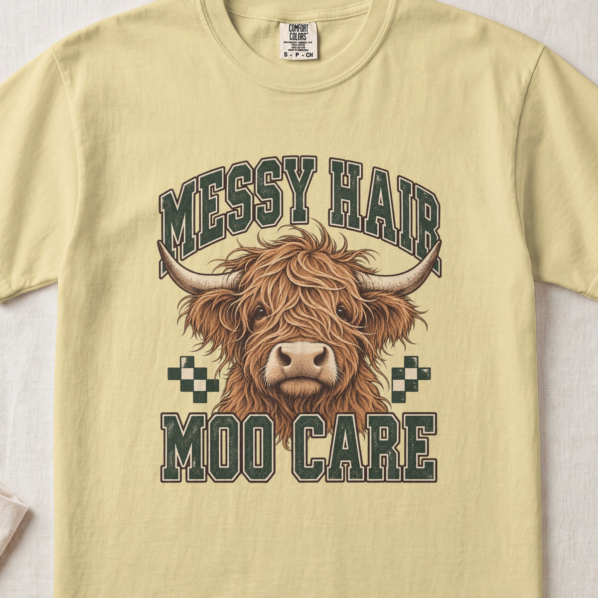Messy Hair, Moo Care Highland cow design on a Butter Comfort Colors 1717 T-shirt, flat lay