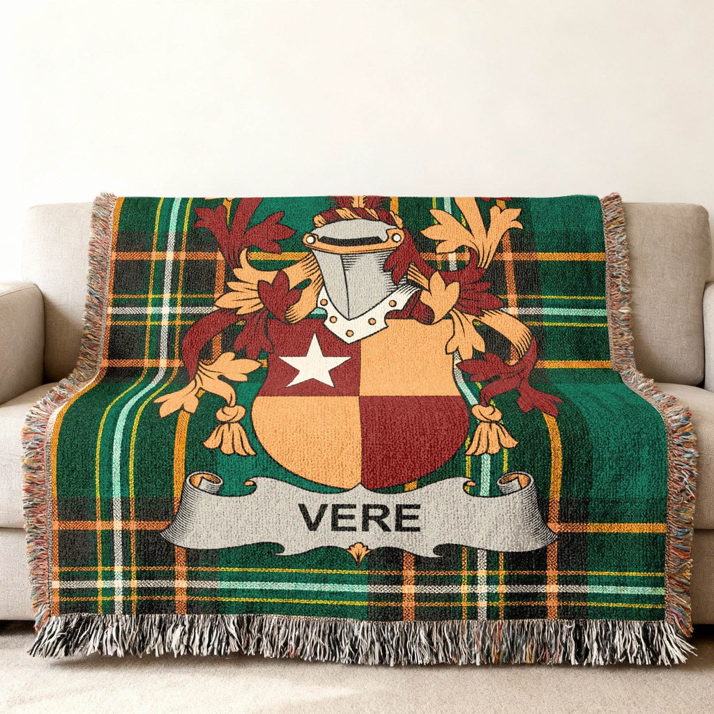 Woven blanket with a green plaid pattern and a family crest featuring a shield with "VERE".