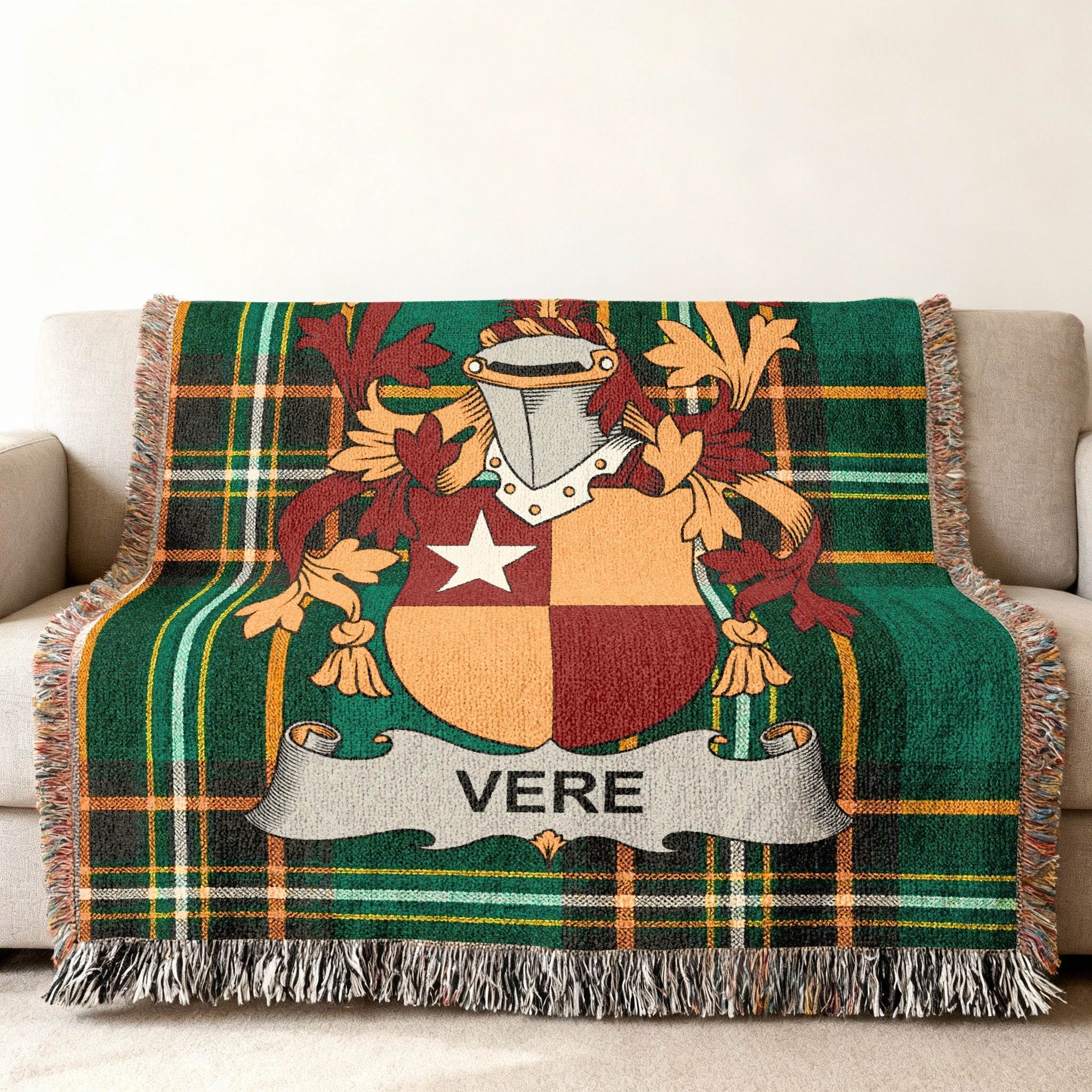Woven blanket with a green plaid pattern and a family crest featuring a shield with "VERE".