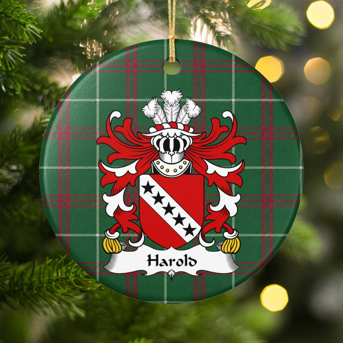 Harold ornament hanging in a Christmas tree with warm lights; five black stars on a white diagonal band across a red shield on Welsh national tartan.