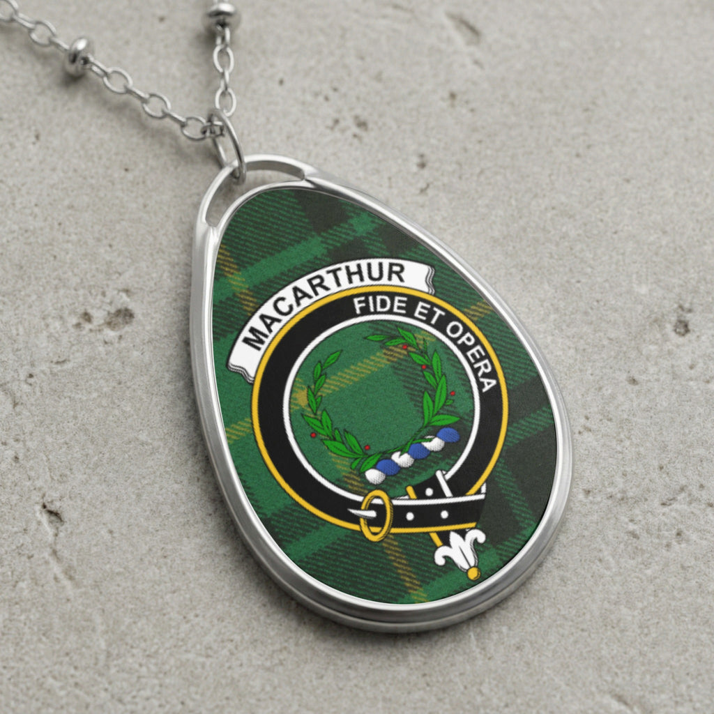 Oval pendant necklace with Macarthur clan crest and plaid background.
