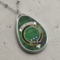 Oval pendant necklace with Macarthur clan crest and plaid background.