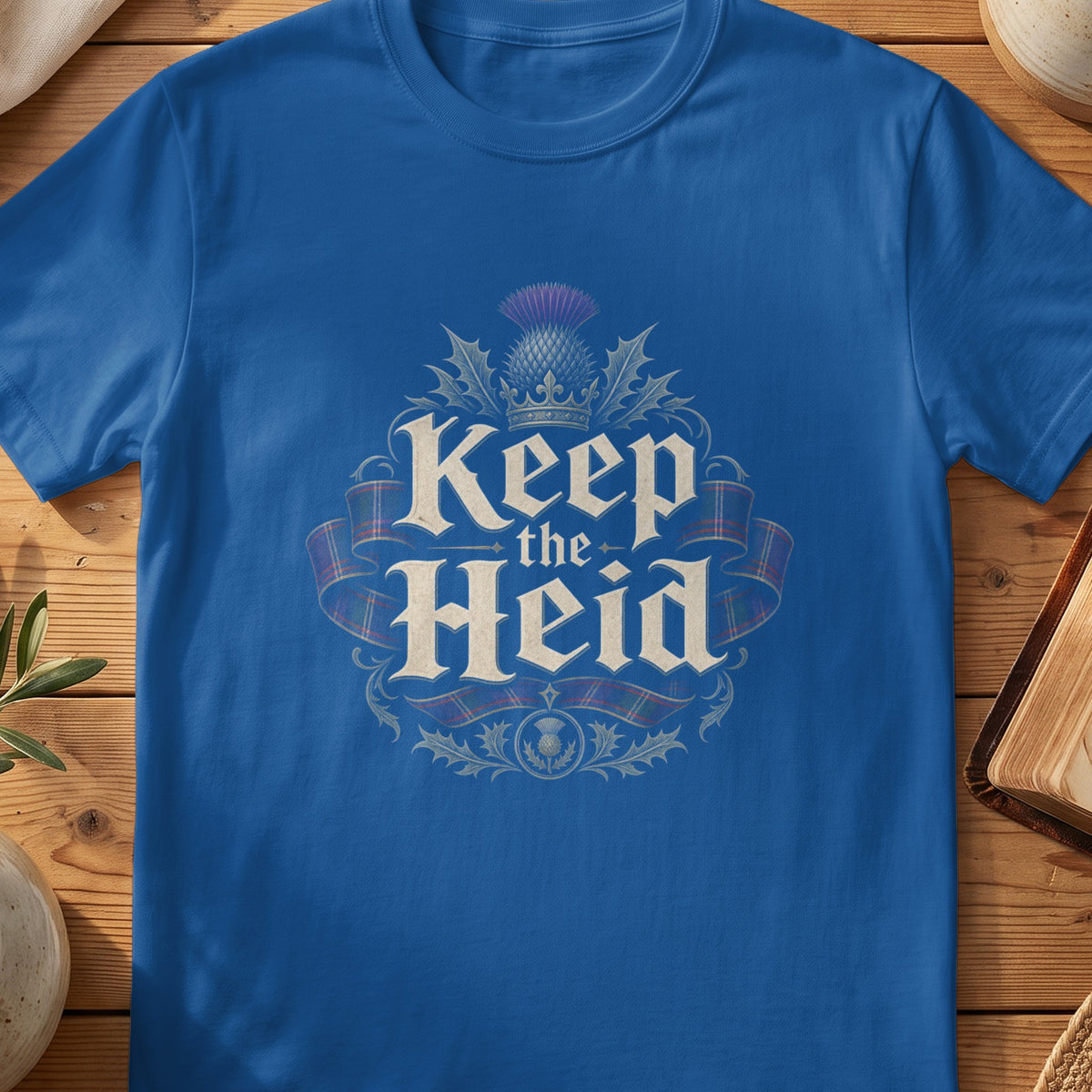 Royal blue t-shirt with "Keep the Heid" text, thistle, and tartan ribbon design.