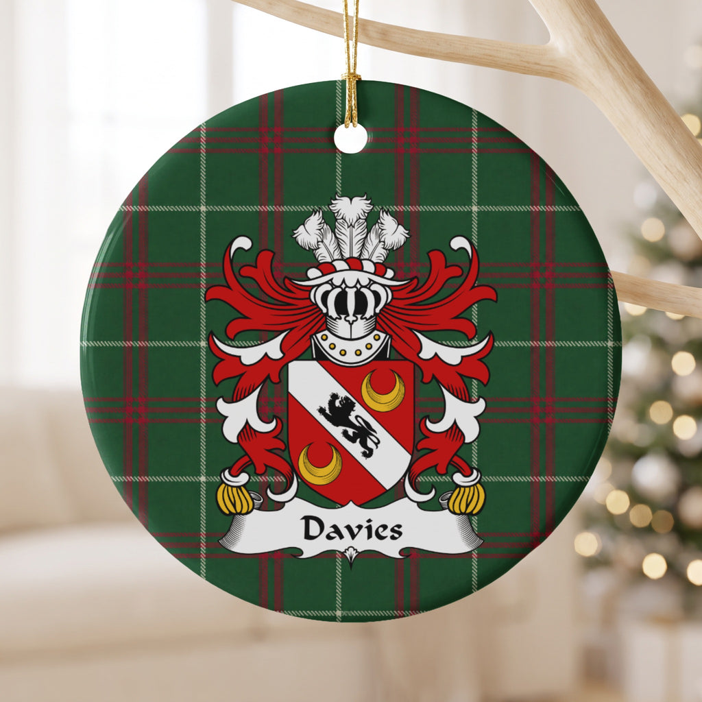 Davies Style 2 ornament hanging from a pale wooden branch; a black lion on a white diagonal band with two gold crescents on red on Welsh national tartan.