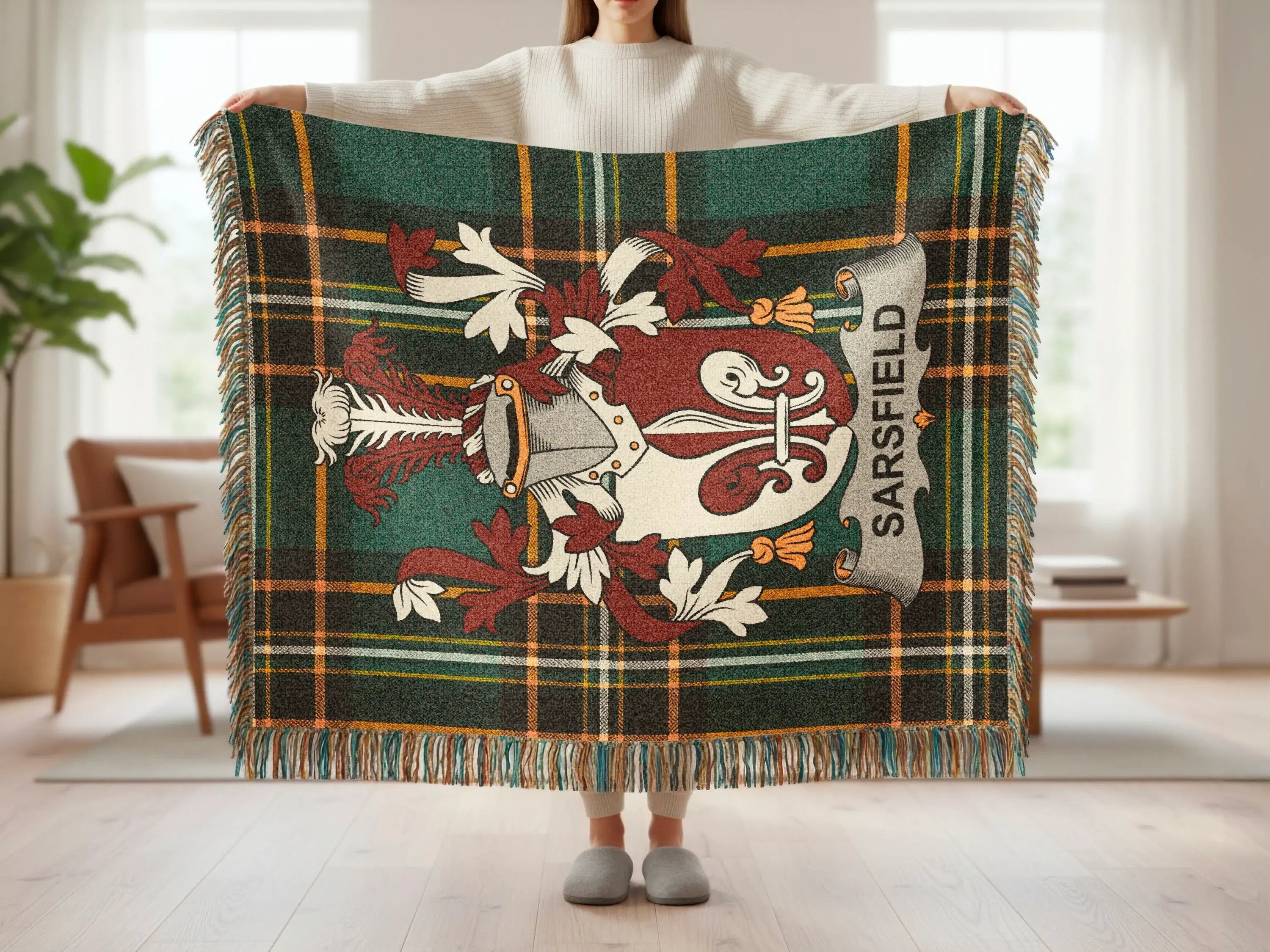 Tartan blanket with Sairsfield coat of arms and fringe, held by a person.